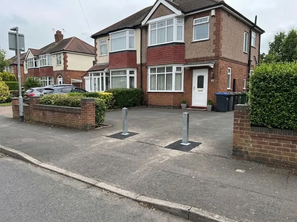 Two galvanised PostSecure telescopic driveway security posts installed in front of a residential property